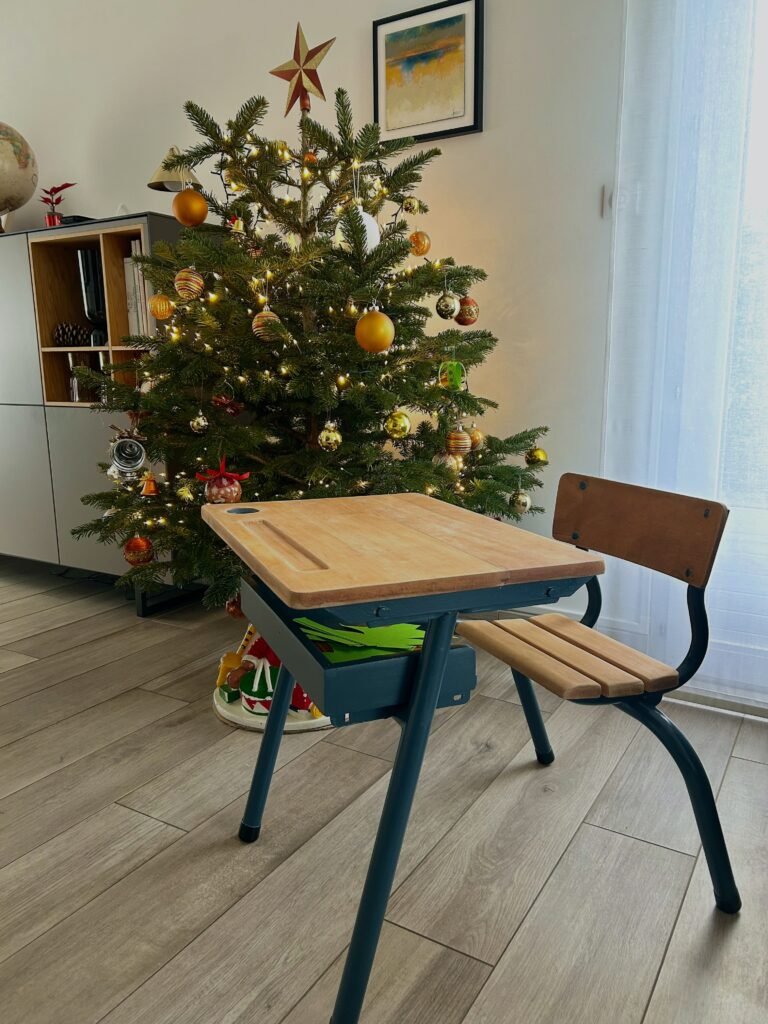 Un petit bureau d'écolier bleu, mis sous le sapin de Noel