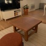 Une table basse carrée en bois dans un salon
