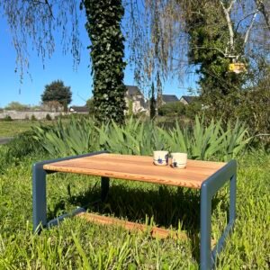 Une table basse en pin, dont les pieds ont été peints en bleu