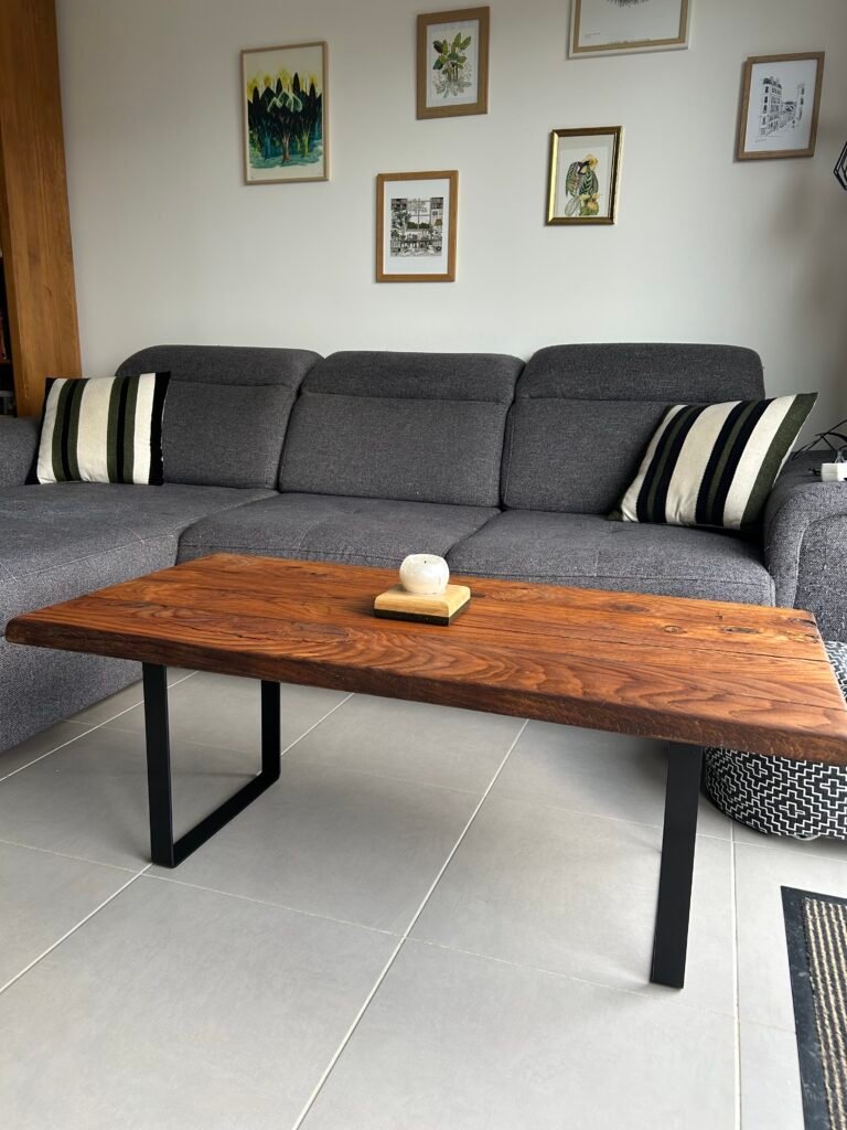 Une table basse avec un plateau en bois massif et des pieds en métal